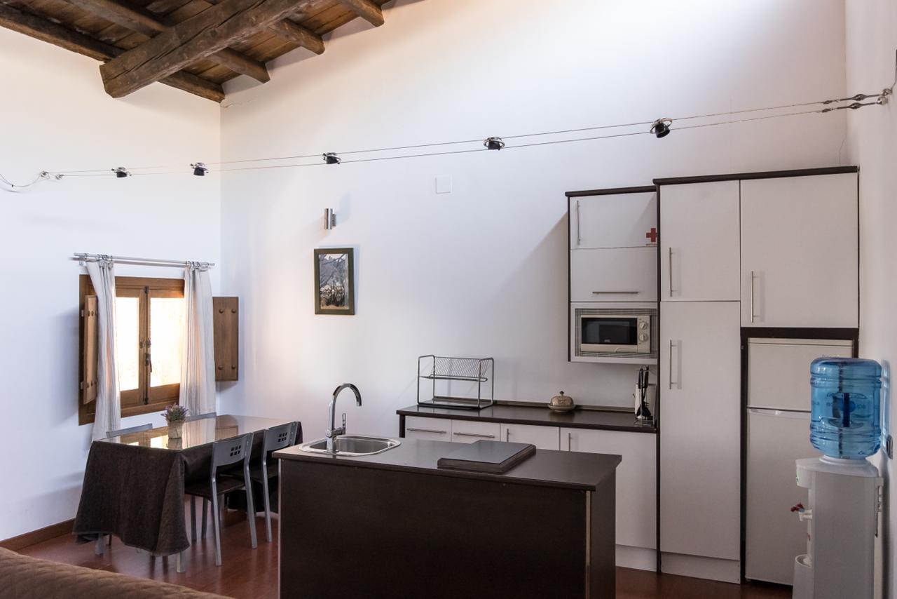 Wider view of the apartment kitchen with dining table.