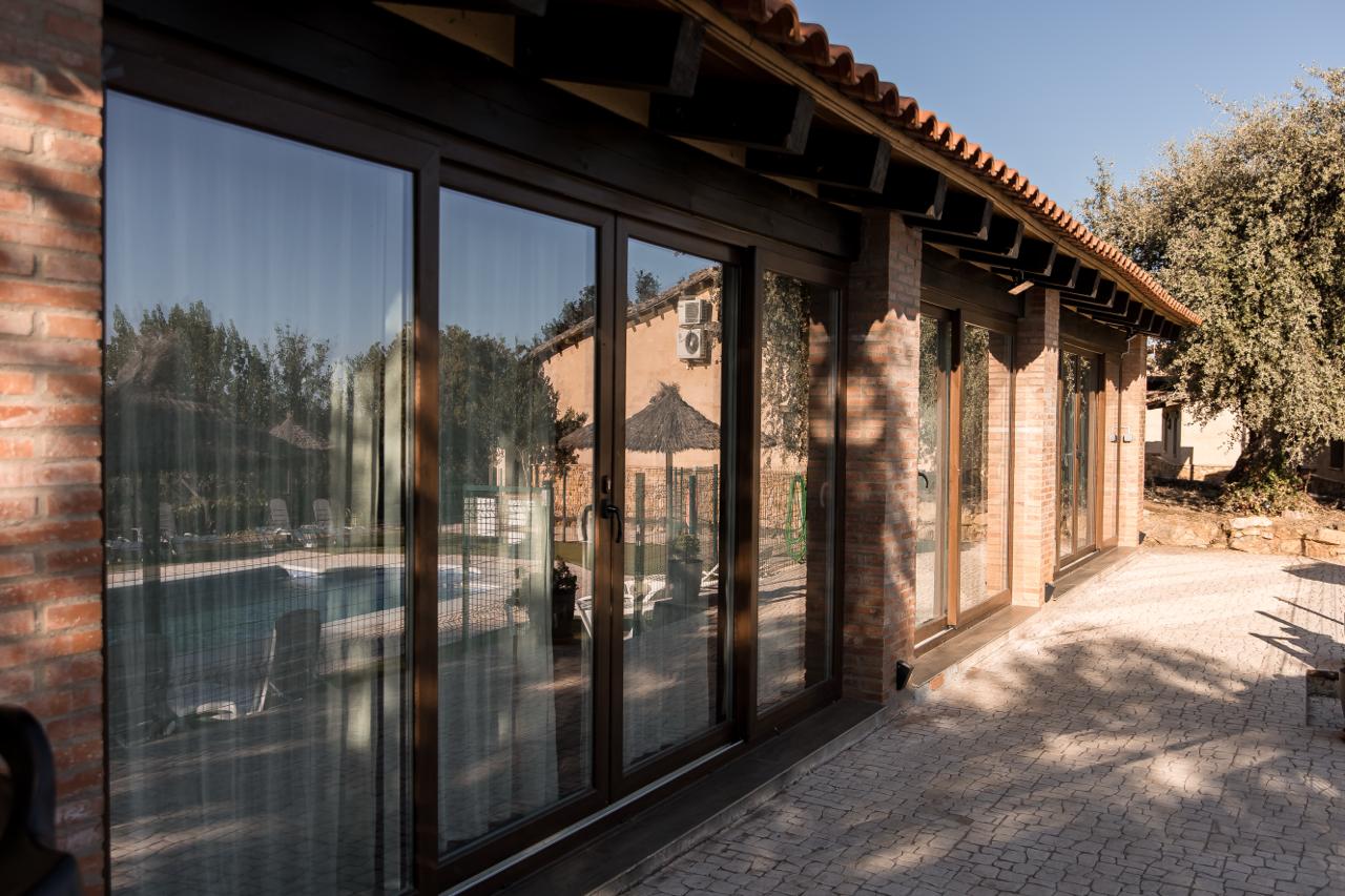 Brick pillars and sliding glass doors of the pavilion, with a paved terrace.