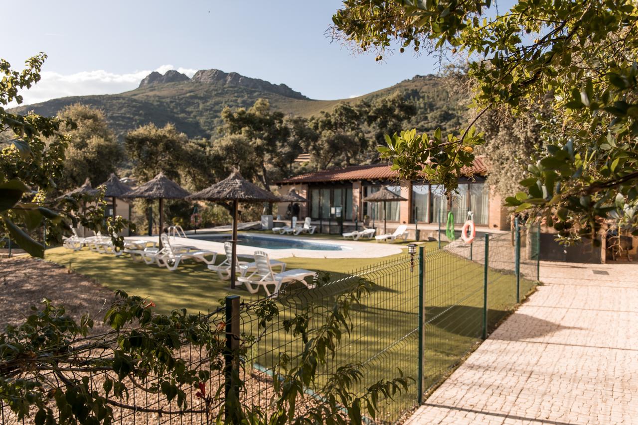 The pool and dining pavilion seen from the garden, with the Sierra de Villuercas rising behind.